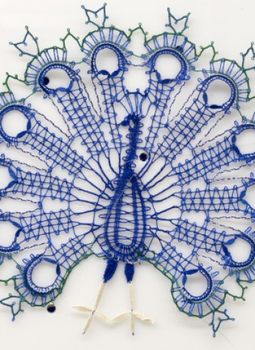 Koronkowy paw wykonany z niebieskich nici.